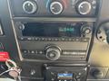 Dashboard of a 2020 Chevrolet Express featuring climate control knobs radio interface and a digital clock display