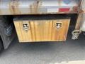 A rusty metal storage box mounted on the rear of a 2016 RAM 5500 truck with two locks on the front