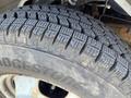 Close-up of a treaded tire mounted on a 2013 Chevrolet Express showing the Bridgestone brand and detailed patterns on the tire surface