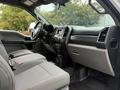 Interior of a 2018 Ford F-550 featuring gray cloth seats and a dashboard with a touchscreen display and control buttons