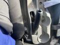 Interior view of a 2019 Hino 195 showing the gear shift lever and cup holder area with visible dirt and items in the space