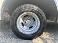 Close-up of a tire mounted on a 2012 Ford E-450 showing a silver wheel with a five-bolt pattern and a black all-season tire