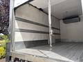 Interior view of a 2018 Hino 195 box truck showing a clean cargo area with metal tracks for securing loads and a single strap hanging from the ceiling