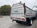 A 2017 Autocar Xpert truck with a silver metal body features a rear sign that reads "CAUTION FREQUENT STOPS AND WIDE RIGHT TURNS"