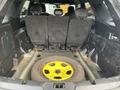 The image shows the interior of a 2021 Ford Explorer with the rear seats folded down and a spare tire with a yellow rim visible in the cargo area