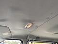 Interior view of a 2010 Ford Econoline showing the ceiling with a dome light and textured fabric surface