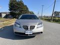 A 2006 Pontiac G6 in a light beige color parked on a road with a visible front view showcasing its headlights and grille design