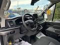 Interior view of a 2020 Ford Transit 250 featuring a steering wheel dashboard and front seats with a touchscreen display on the center console