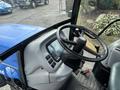 Interior view of a 2009 New Holland T4020 tractor featuring a steering wheel a control panel and various knobs and buttons