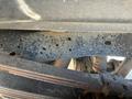 A close-up view of the undercarriage of a 2016 Ford F-250 SD showing a metal frame with visible rust spots and holes