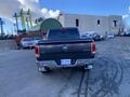 A rear view of a 2017 RAM 1500 truck with red taillights and a silver logo on the tailgate