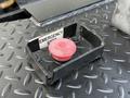Red emergency stop button in a black metal housing labeled Emergency Stop