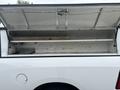 A 2016 RAM 1500 with an open truck bed cap revealing a wooden plank and shelves inside the cap
