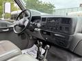 Interior view of a 2004 Ford F-750 showing the dashboard gear shift and various controls with a steering wheel and seating area visible