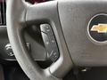 Close-up of a Chevrolet Express steering wheel with buttons for cruise control and the Chevrolet logo