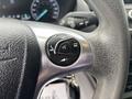Close-up of a steering wheel control panel featuring buttons for volume and phone functions in a 2019 Ford Transit Connect