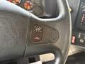 Close-up of a steering wheel featuring a button labeled Flashers On Off with a red light indicator and an additional label for Red Override