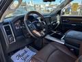 Interior of a 2015 RAM 1500 featuring a steering wheel dashboard and leather seats with a central console and gear shift