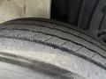 A close-up of a worn tire from a 2011 International 4300 showing visible tread wear and a rough surface