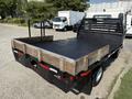 A 2012 Hino 155 flatbed truck with a wooden frame and black metal surface showing a low profile and sturdy construction