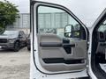 A 2018 Ford F-550 with an open driver's side door showcasing the interior door panel and controls