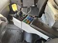 The interior console of a 2013 Freightliner 114SD featuring multiple control levers and buttons in various colors arranged in a compact layout