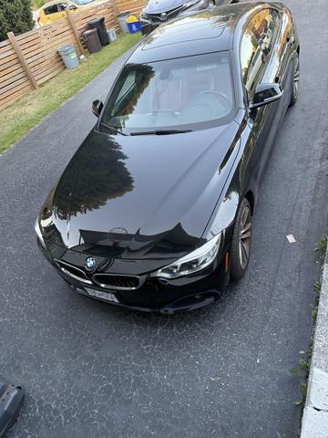 A 2016 BMW 4-Series Gran Coupe in black with sleek lines and a sporty design showcasing the front grille and headlights