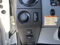 Dashboard controls of a 2011 Ford F-550 featuring knobs for lights and PTO along with a warning label
