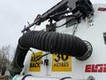 A close-up view of the rear of a 2009 UD Trucks UD 3300 featuring a large black hose and warning signs that read KEEP BACK and 30 METRES
