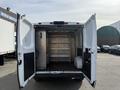 A 2017 RAM Promaster van with its back doors open revealing an empty interior with metal shelving units and a storage compartment