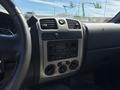 Interior console of a 2011 Chevrolet Colorado featuring controls for audio and climate with various knobs and buttons