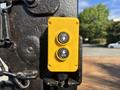 A yellow control panel with two buttons labeled UP and DN mounted on a metal post