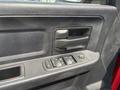 Close-up of the door panel of a 2013 RAM 2500 featuring window controls and a door handle in a textured black finish