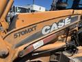 A 2011 Case 570 MXT backhoe loader with orange and gray coloration displaying the model number and brand name on its side
