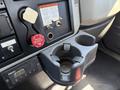 Close-up of the interior console of a 2013 International 7400 featuring a cup holder and various controls including an air supply connection and warning labels