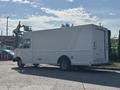 A white 2012 Ford E-450 box truck with a side door and a raised device on the roof, showcasing a streamlined design for commercial use