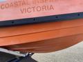 A 2007 Fassmer 20 Foot Fast Rescue Boat with an orange hull and black trim displaying the text COASTAL INSPIRATION VICTORIA
