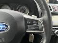 A close-up view of the steering wheel of a 2016 Subaru Forester featuring control buttons for cruise control and a Subaru logo