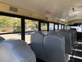 Interior view of a 2013 International CE300 school bus with grey seats visible in rows and windows alongside