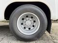 A close-up of a wheel from a 2002 Ford Econoline featuring a silver rim and a rugged Toyo Open Country tire
