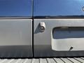 A 2016 Ford Transit 150 with a side view showing the door seam and a small sensor near the bottom of the rear door