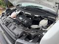 A 2020 Chevrolet Express with its hood open displaying the engine compartment featuring various components and a large air intake system