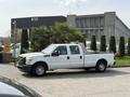 A white 2011 Ford F-350 SD pickup truck parked with a flatbed and double cab