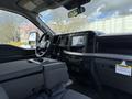 Interior of a 2024 Ford F-550 featuring a steering wheel a central touchscreen display and a console with storage space
