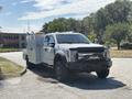 A 2017 Ford F-550 equipped with a utility box and a front bull bar in a parking area
