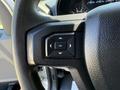 Close-up of the steering wheel control buttons of a 2017 Ford F-350 SD showing directional arrows and an OK button
