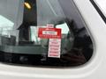 A 2012 International 7400 vehicle with a red inspection sticker attached to the window displaying certificate details and months of the year