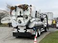 A 2013 International Workstar 7500 truck with a vacuum tank and multiple hoses attached at the rear for industrial cleaning purposes