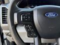 Close-up of the steering wheel of a 2020 Ford F-350 SD showing control buttons and the Ford logo