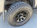 Close-up of a black wheel with a Falken tire mounted on a 2010 Toyota Tacoma, featuring deep treads and a multi-spoke design